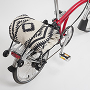 Brompton Faltrad House Red mit schwarz weißem Badehandtuch auf dem Gepäckträger