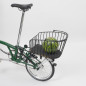 Preview: Der Rixen & Kaul Gepäckträgerkorb KLICKfix Alumino GT in Black ist auf den Gepäckträger eines grünen Brompton Faltrades geklippt, im Korb liegt eine Melone