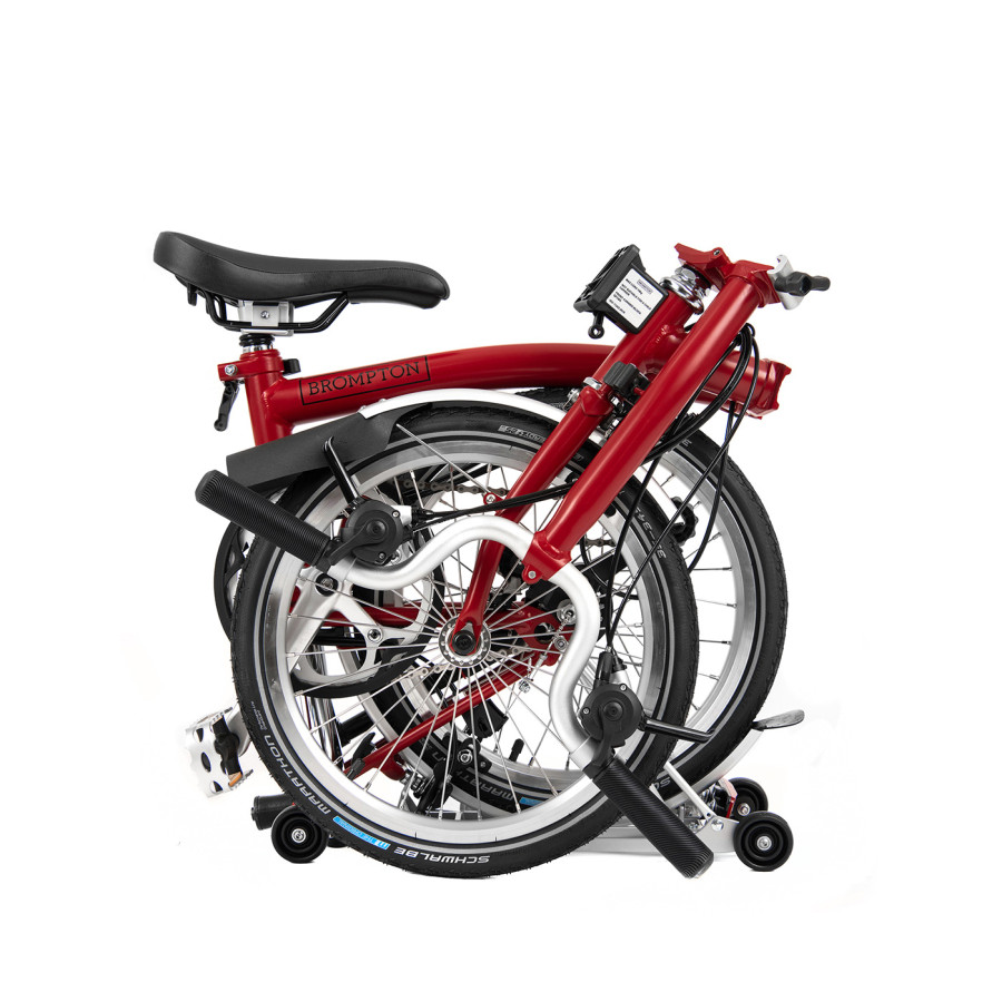 Ein gefaltetes Faltrad von Brompton in der Farbe House Red ist abgebildet.