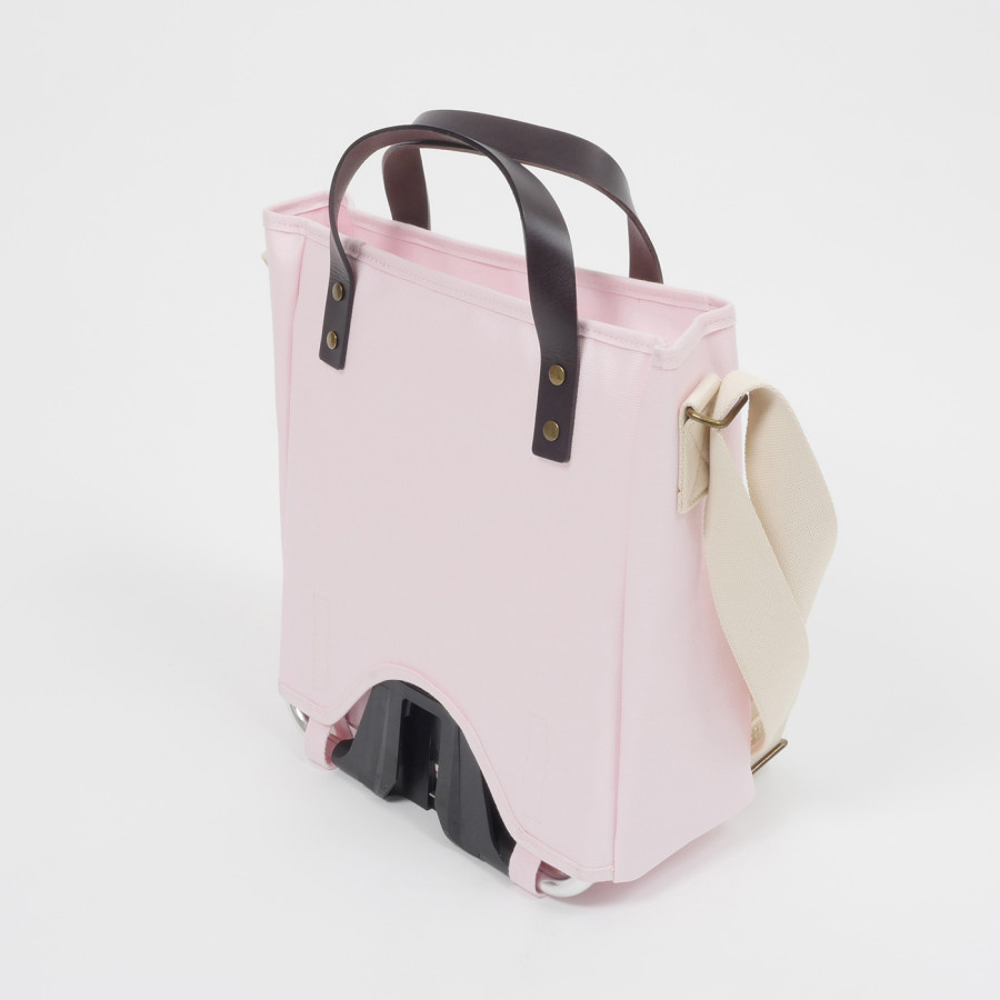 Die Brompton Tote Bag in rosa ist als Freisteller schräg von hinten abgelichtet, der Frame Carrier Block ist deutlich zu sehen