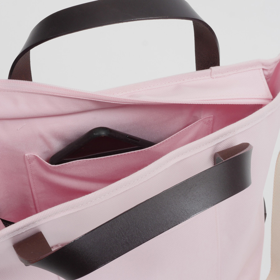 Blick in das Innenleben einer rosa Tote Bag, ein Handy in der innenliegenden Handytasche ist zu sehen