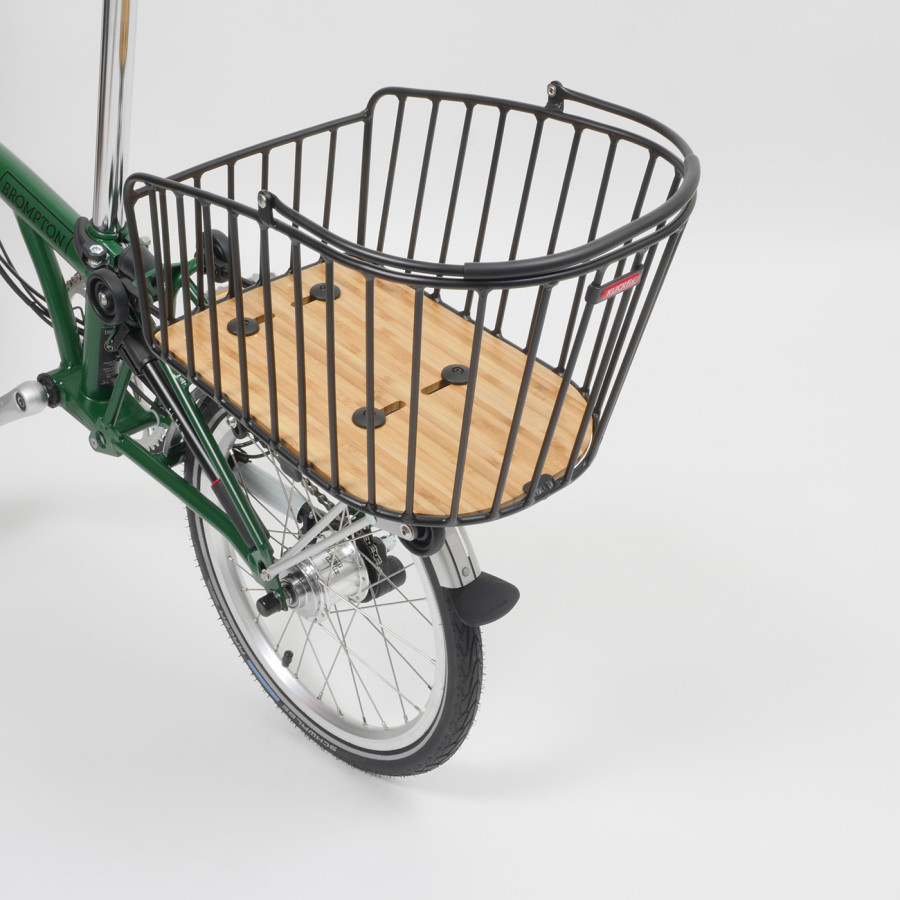 In Nahaufnahme der Rixen & Kaul Gepäckträgerkorb KLICKfix Alumino GT in schwarz, der auf den Gepäckträger eines grünen Brompton Faltrades geklippt ist