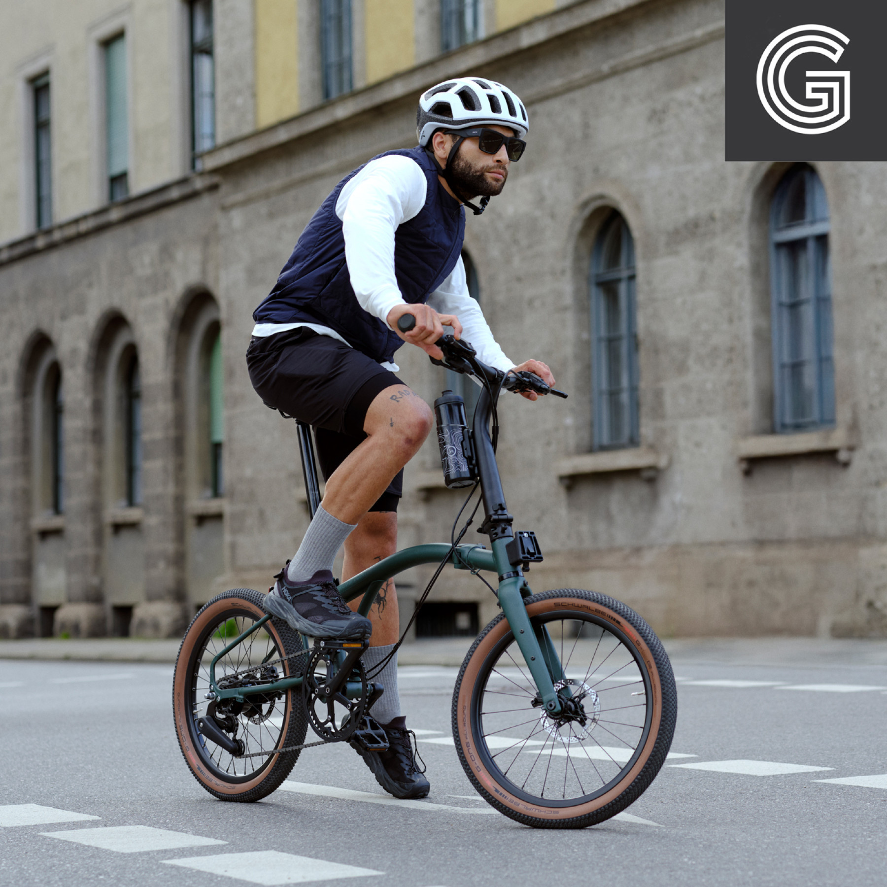 Brompton G Line Forest Green Large. Imagebild mit Faltrad und Fahrer, 01.