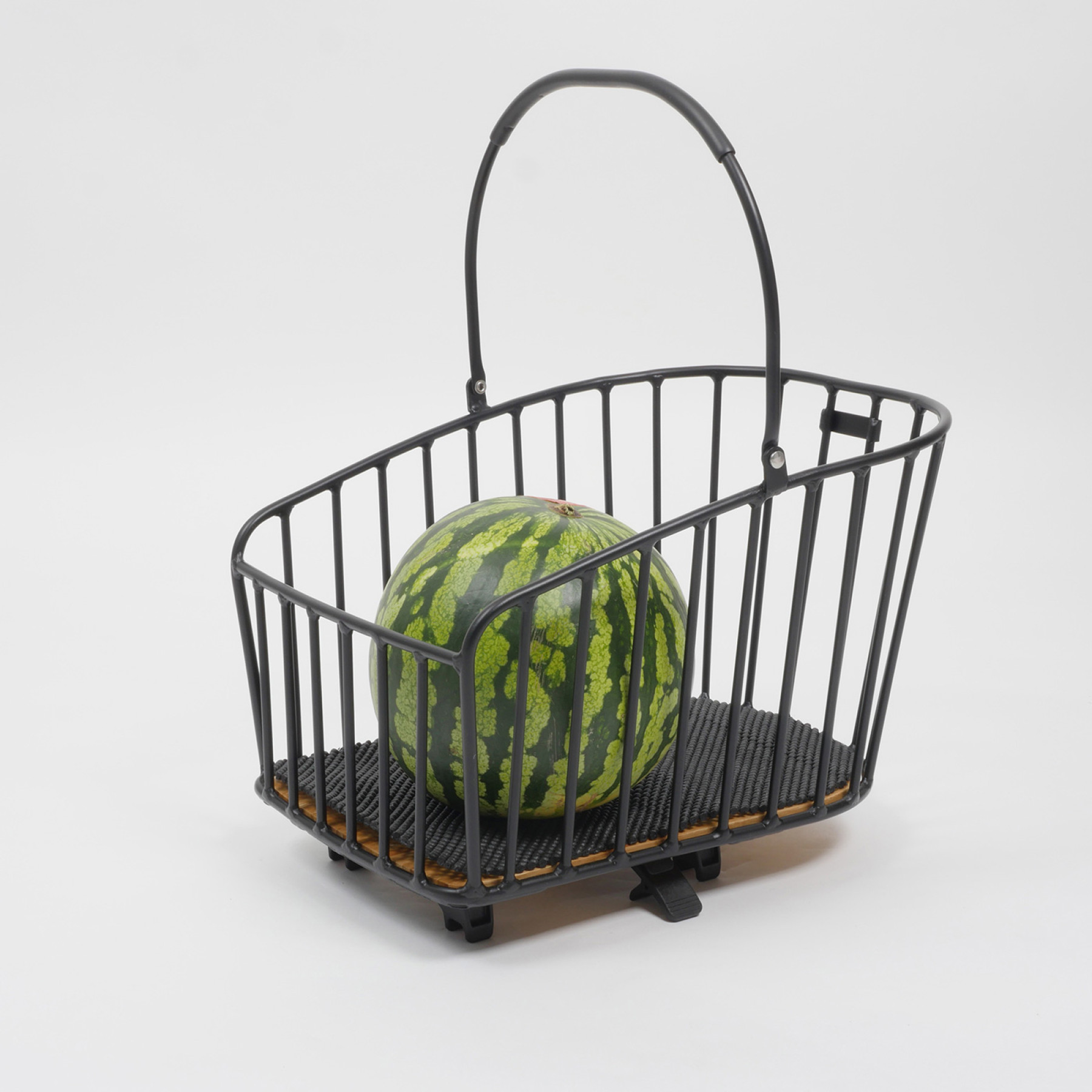Der Rixen & Kaul Gepäckträgerkorb KLICKfix Alumino GT in Black ist auf weißem Hintergrund fotografiert, eine Melone liegt im Innenraum