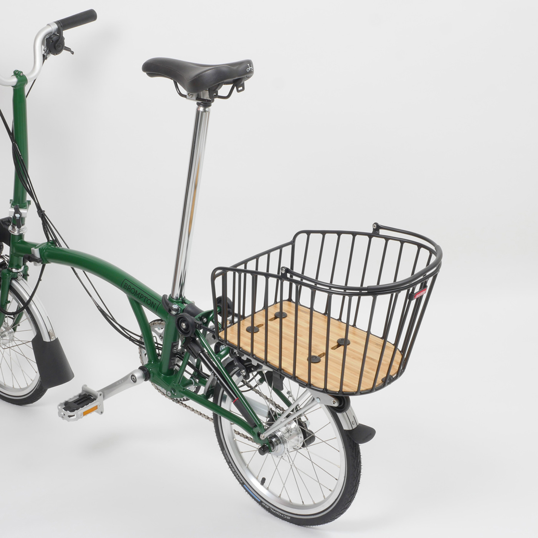 Der Rixen & Kaul Gepäckträgerkorb KLICKfix Alumino GT in Black ist auf den Gepäckträger eines grünen Brompton Faltrades geklippt