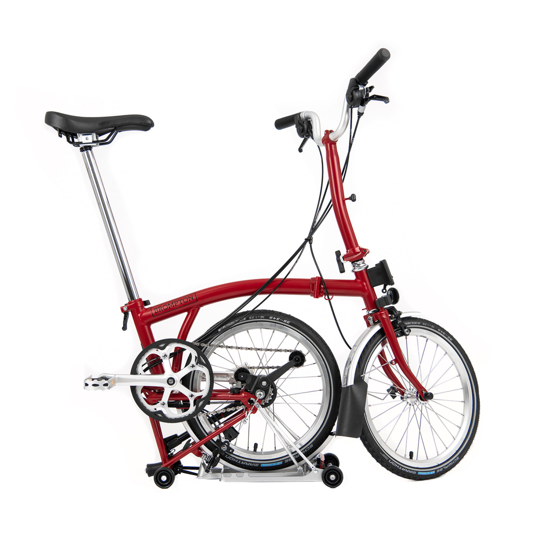 Ein rotes Brompton Faltrad steht mit eingefaltetem Hinterrad als Freisteller vor Weiß.