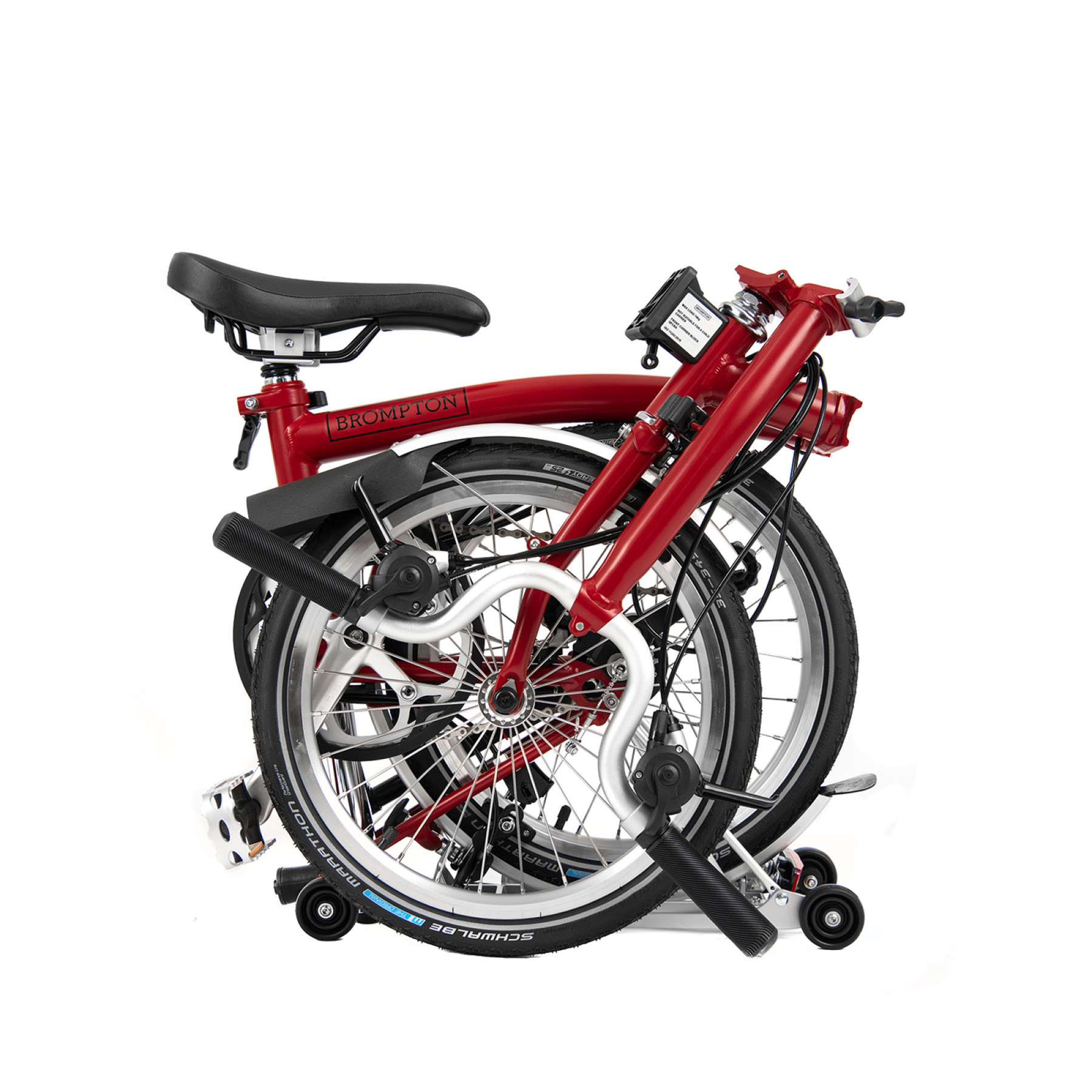 Ein gefaltetes Faltrad von Brompton in der Farbe House Red ist abgebildet.