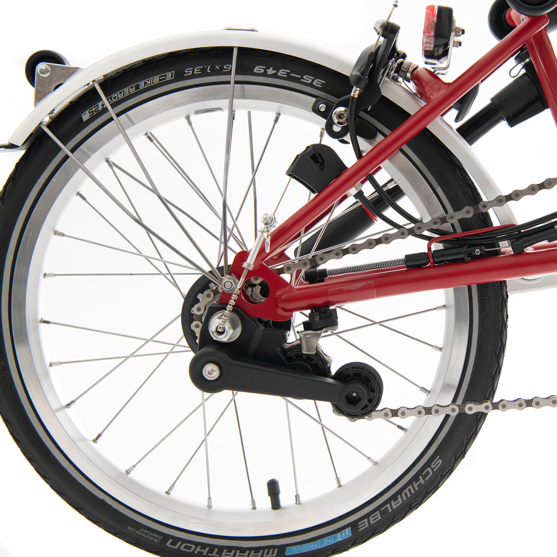 Das Hinterrad eines roten Brompton Faltrades ist ohne Gepäckträger abgelichtet.
